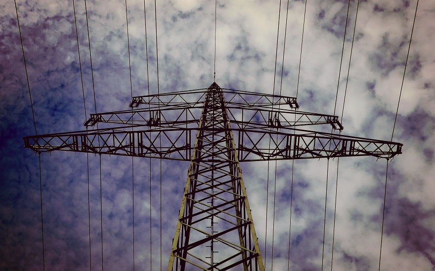 power transmission lines taken against a blue sky with clouds