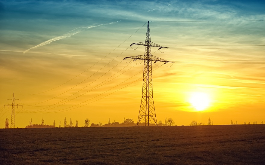 power transmission line with the sun setting in the background