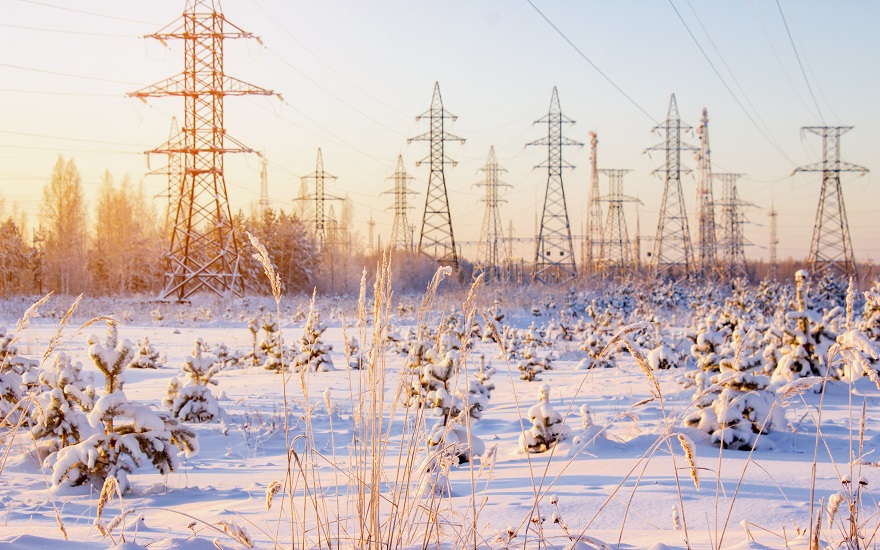 electricity transmission pylons in a field covered by snow